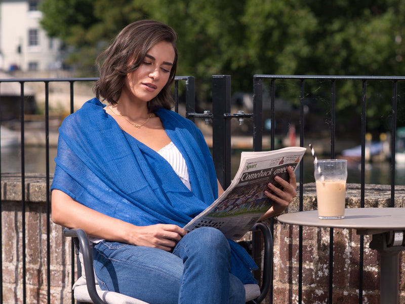 Elia cobalt blue cashmere scarf draped over an evening outfit
